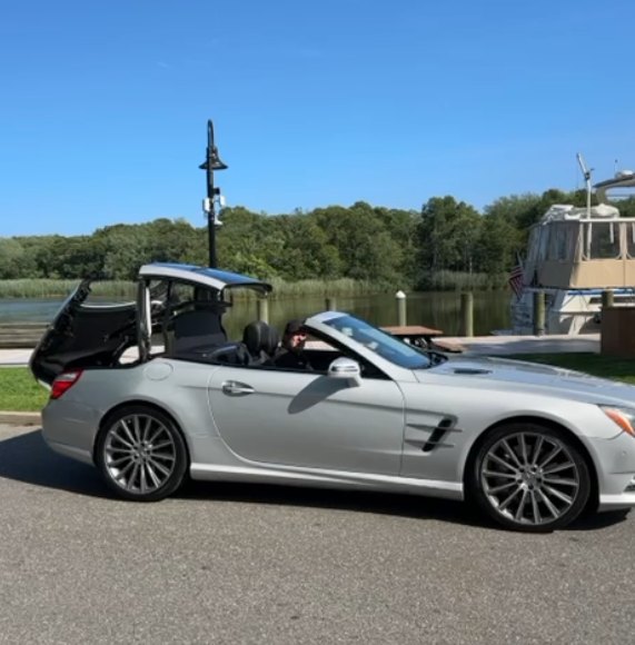 Srebrny Mercedes SL z otwartym dachem nad wodą
