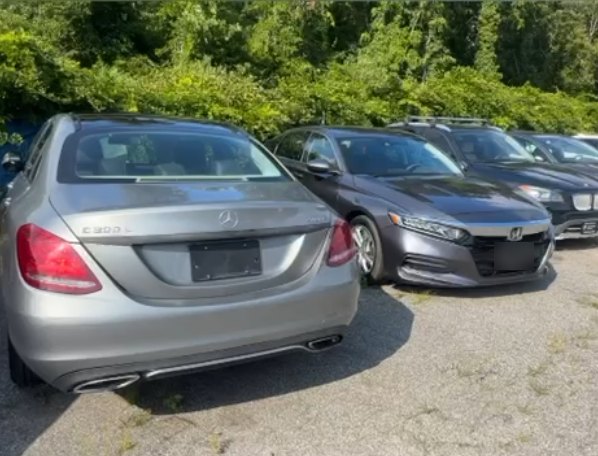 Srebrny Mercedes C300 i szara Honda zaparkowane na placu